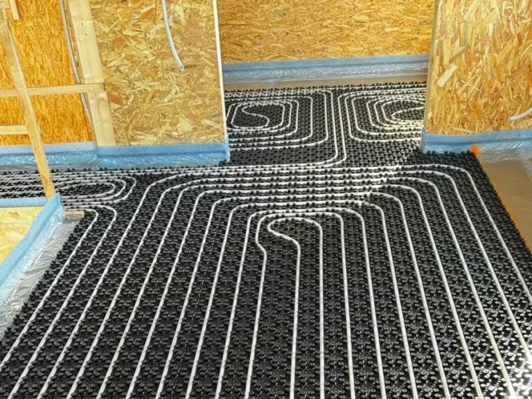 Distribución de suelo radiante en pasillo y habitaciones con tuberías sobre panel aislante negro