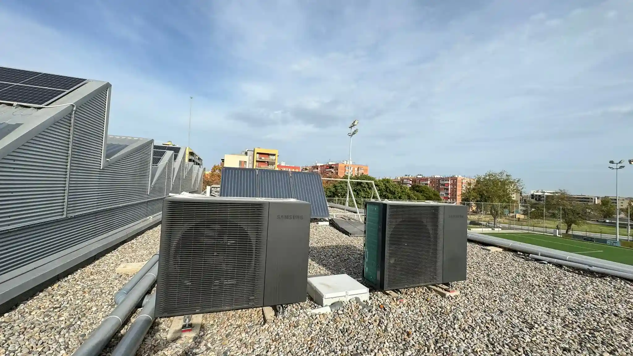 Unidad exterior de aerotermia Samsung instalada en cubierta con grava, parte del sistema de calefacción y refrigeración eficiente.
